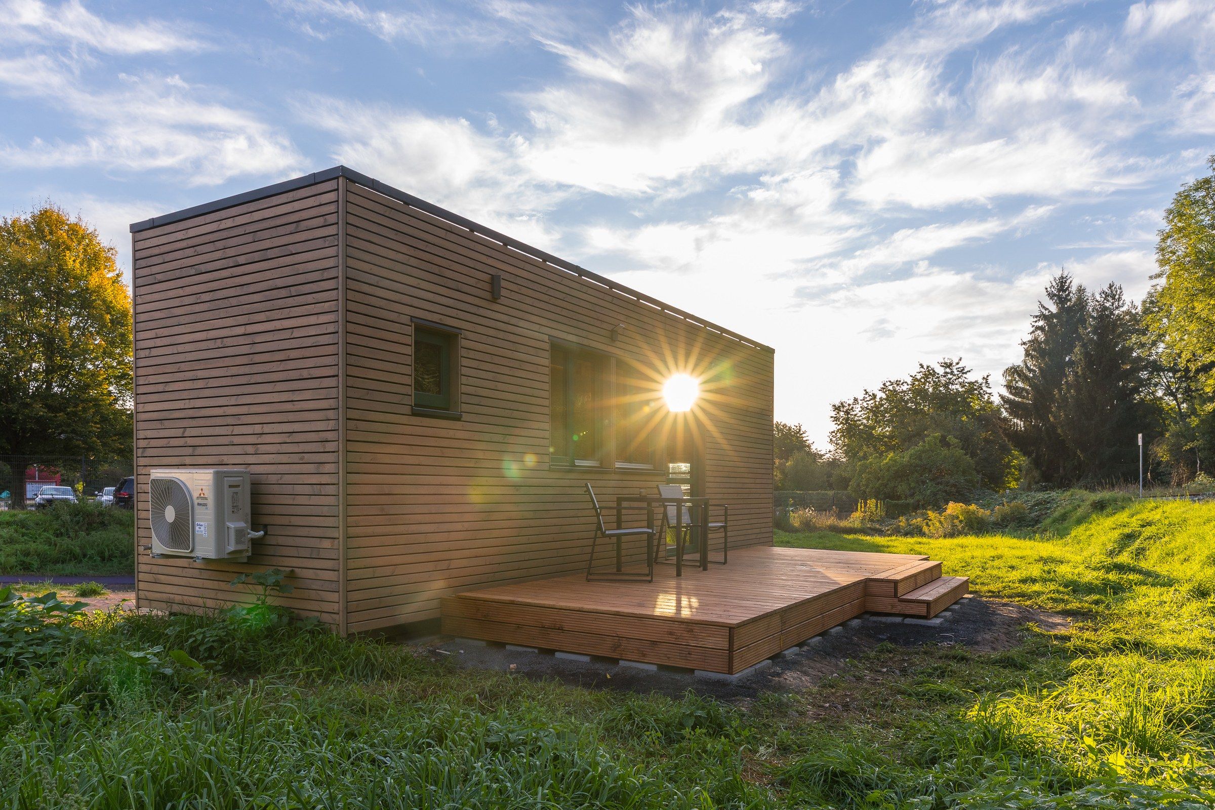 rethink Tiny House mit Holzfassade im Gegenlicht